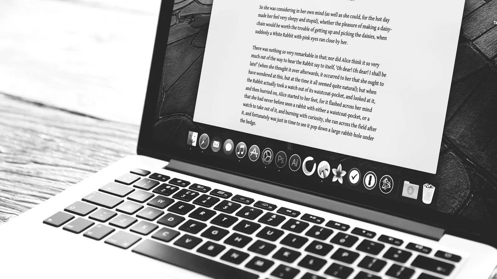 Laptop z otwartym dokumentem tekstowym na drewnianym stole